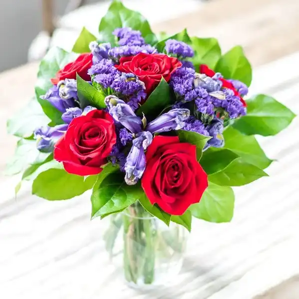 Red Roses and Blue Iris in a Clear Vase