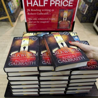 An employee of Waterstones poses with a copy of ‘The Silkworm’ by author Robert Galbraith, aka Harry Potter author J. K. Rowling, as it goes on sale for the first time at a bookshop in London on June 19, 2014.