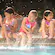 Three young girls react to getting splashed, as they sit on the edge of a Disneyland Resort Hotel pool