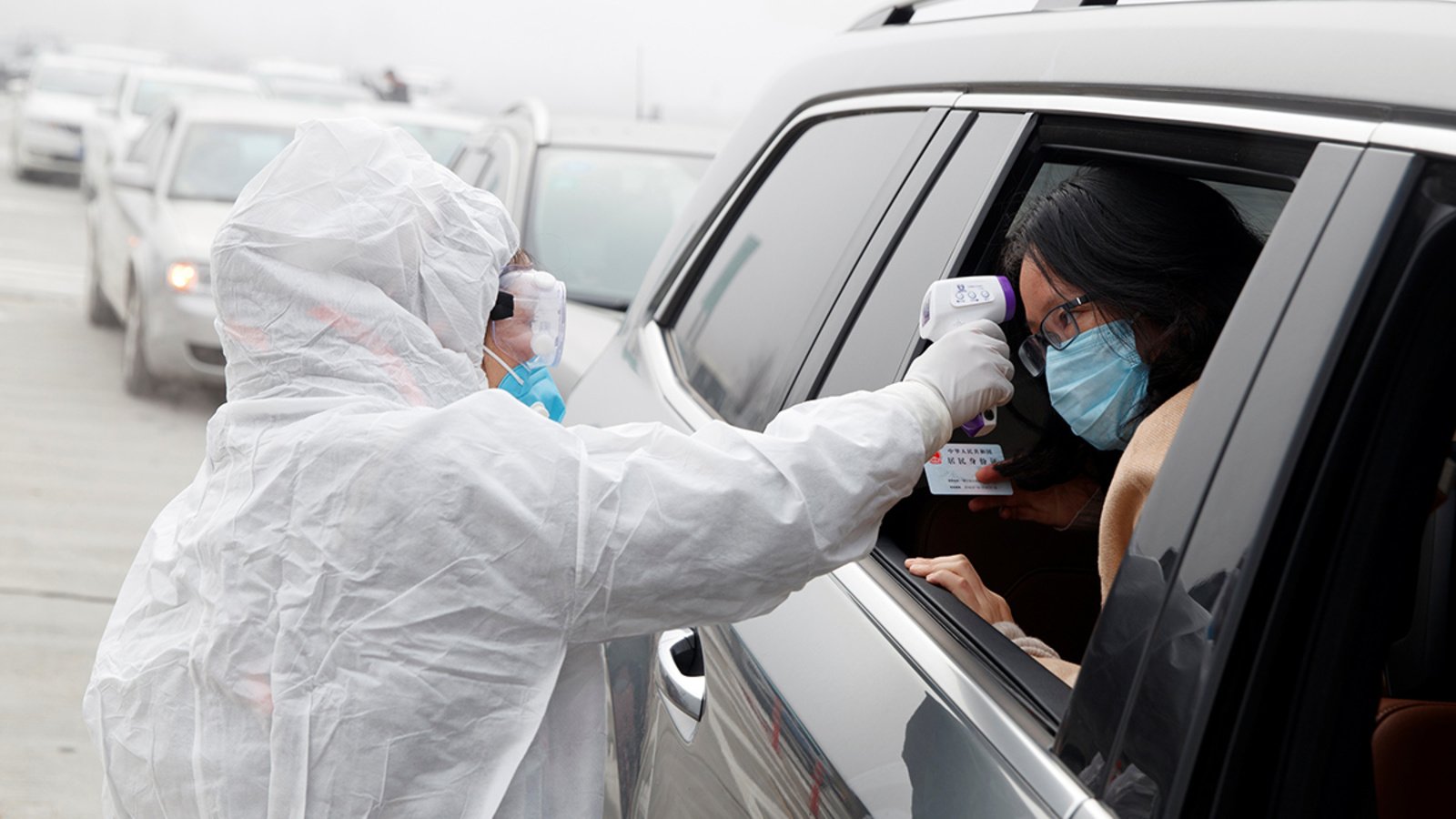 A medical worker checks a person’s temperature in China amid the coronavirus outbreak in January 2020.