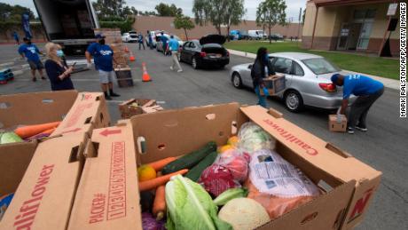 Staff and volunteers with &#39;The Los Angeles Dodgers Foundation&#39;, distribute food and other goods during its second Dodger Day Drive-Thru food bank for people facing economic hardship in Huntington Park, California on June 18, 2020. (Photo by Mark Ralston/AFP/Getty Images)