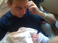 Talking on phone and looking at newborn