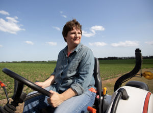 Farmer driving around her field in an ATV
