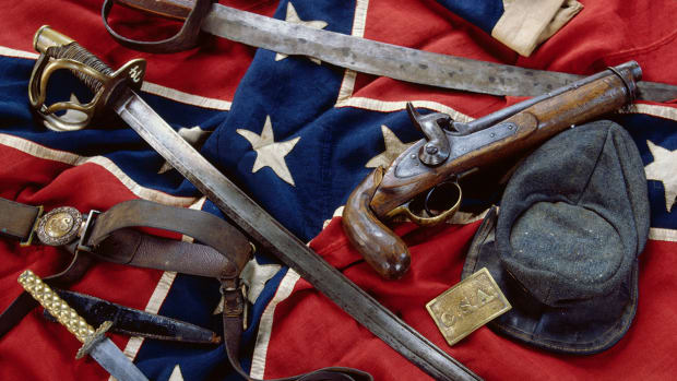 Civil War Confederate artifacts include a rare battleflag in mint condition, a C.S.A belt plate, and a very rare two-piece round buckle with belt. The top saber pictured is almost homemade, while the other is government issue. The kepi is also government issue, but the knife is not. The pistol was already a museum piece during the Civil War. — Image by © Tria Giovan/CORBIS