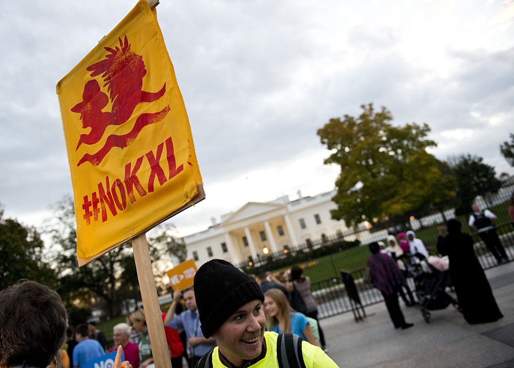 A demonstrator, celebrating US President Barack Obama's blocking of the Keystone XL oil pipeline, holds up a sign during a rally in front of the White House in Washington, D.C. on November 6, 2015.
