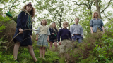 A grouping of slightly wild looking children in the forest